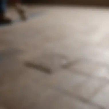 A close-up of a tile being pried from the floor